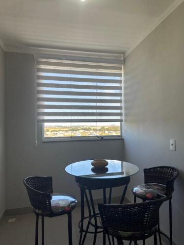 a table and chairs in a room with a window at Apartamento Exclusive in Araçatuba