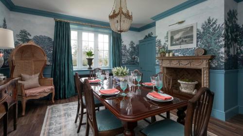 a dining room with a table and a fireplace at Gardener's Cottage, Twizell Estate in Belford