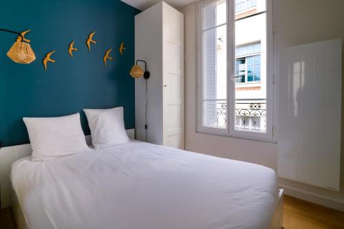 une chambre avec un lit blanc et une fenêtre dans l'établissement Appartement Cosy - Fontainebleau - Proche forêt, à Fontainebleau