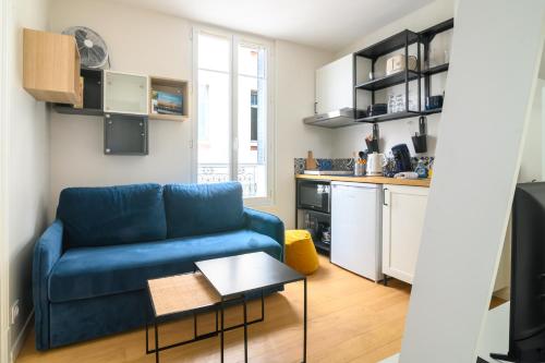 un salon avec un canapé bleu et une table dans l'établissement Appartement Cosy - Fontainebleau - Proche forêt, à Fontainebleau