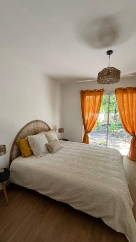 une chambre avec un grand lit et une fenêtre dans l'établissement Villa Oyat entre foret et océan, à Grayan-et-lʼHôpital