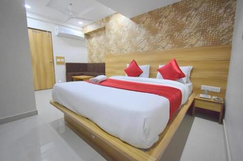 艾哈迈达巴德Hotel Midnight的卧室里有一张大床，配有红色枕头