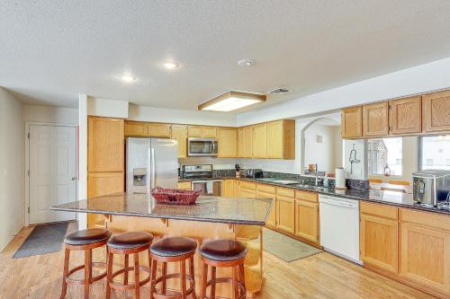 a large kitchen with wooden cabinets and a island with bar stools at Spacious Parker Home with On-Site River Access! in Parker