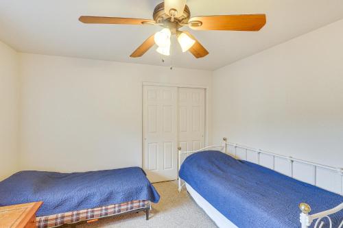 a bedroom with a ceiling fan and a blue bed at Spacious Parker Home with On-Site River Access! in Parker