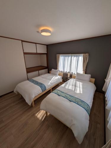 a room with two beds and a window at Villa Ishiba-Otsu by Kyoto ヴィラ石場大津 by 京都 in Otsu