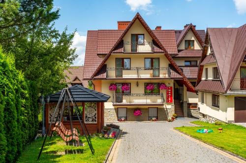 una casa grande con un parque infantil delante de ella en Pokoje Gościnne u Moniki Zakopane, en Zakopane