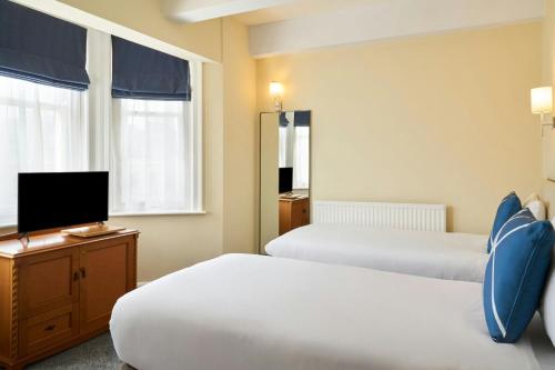 a hotel room with two beds and a flat screen tv at Four Points Flex by Sheraton Brighton in Brighton & Hove