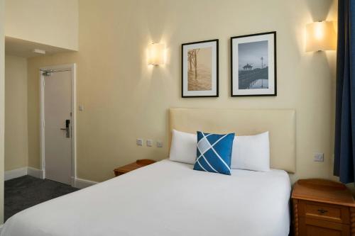 a bedroom with a large white bed with two pictures on the wall at Four Points Flex by Sheraton Brighton in Brighton & Hove