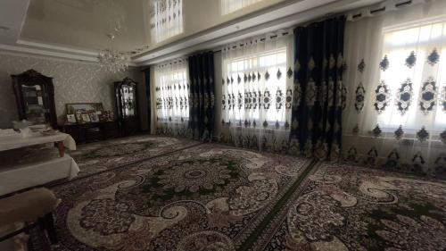 una sala de estar con una alfombra grande y ventanas en Дом, 