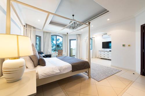 a bedroom with a canopy bed and a living room at Palm Jumeirah Beachfront private pool villa 5 BR & 1 maids room with access to beach in Dubai