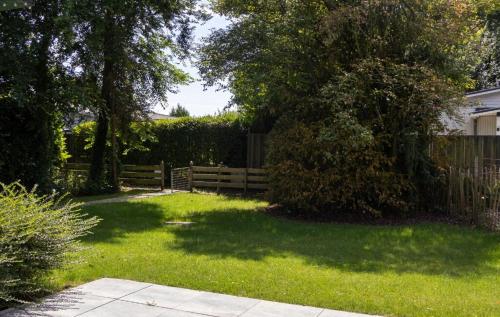 a yard with a wooden fence and green grass at House & More near the IJsselmeer in Lemmer