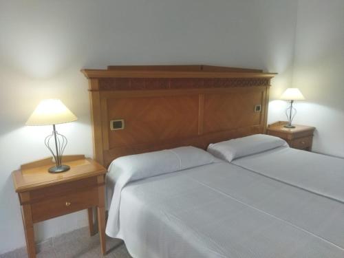a bedroom with a bed and two night stands with lamps at Apartamentos Pez Azul in Puerto de la Cruz