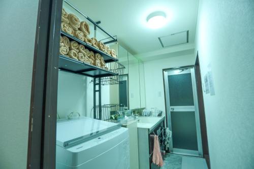 a white bathroom with a sink and a mirror at Nagoya Apartment Oosu in Minami-sotoborichō