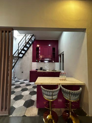 a kitchen with purple cabinets and a counter with bar stools at ADS House in Padalarang