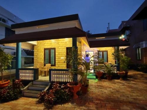 a house with a patio with benches and plants at ARONIC beach hotel in Varkala