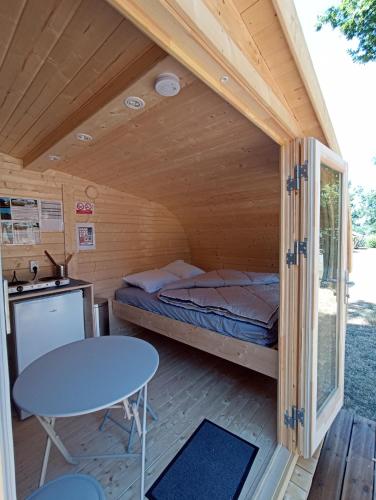 a room with a bed and a table in a cabin at Camping Municipal Tindio in Arzon