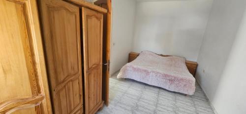 Un dormitorio con una cama y una puerta abierta. en une chambre, un salon, cuisine et balcon, en Monastir