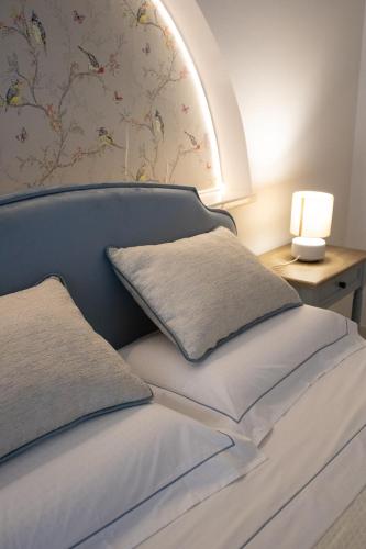a bed with a headboard with a lamp on a table at Chicca Casa Vacanze in Casarano