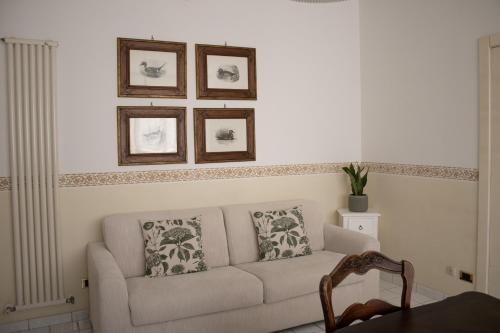 a living room with a couch and three pictures on the wall at Chicca Casa Vacanze in Casarano