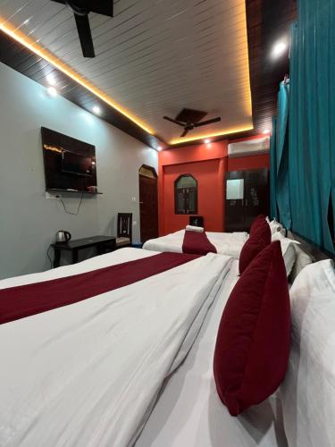 a hotel room with two beds with red walls at The Aryakulam Heaven Near Ayodhya Dham in Ayodhya