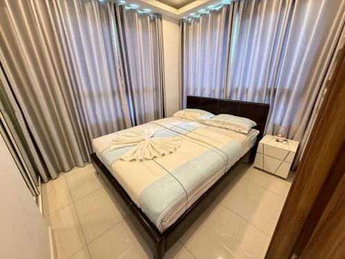 a bedroom with a large bed in a room with curtains at Arcadia Beach Resort Tatil Merkezi in Pattaya South