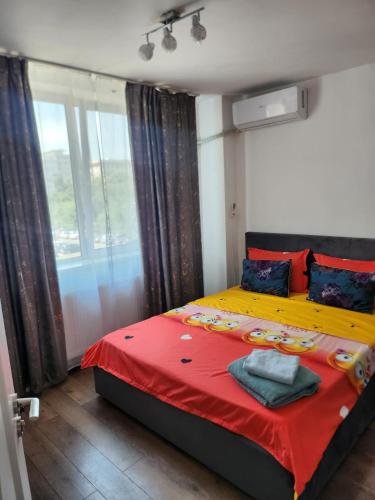 a bedroom with a bed with a red blanket and a window at Exceptional Apartment - Gara de Nord in Bucharest