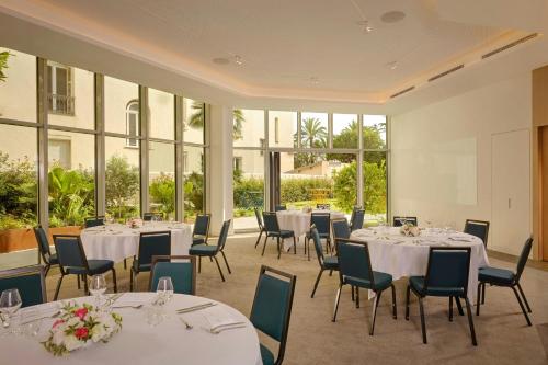 a conference room with tables and chairs and windows at AC Hotel by Marriott Nice in Nice