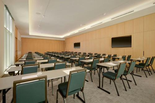 a large room with tables and chairs and a tv at AC Hotel by Marriott Nice in Nice