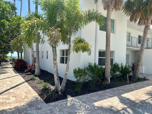 a white building with palm trees in front of it at 7th Heaven condo in Longboat Key
