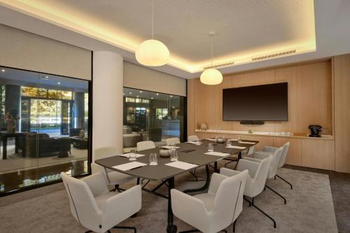 a dining room with a table and white chairs at AC Hotel by Marriott Nice in Nice