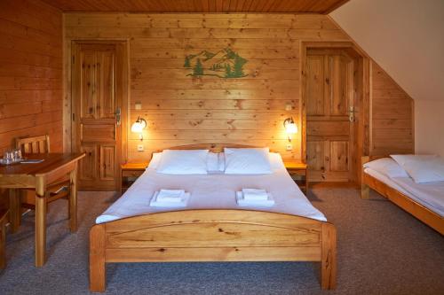 a bedroom with a bed and a wooden wall at Penzion pod Šerákem in Ostružná