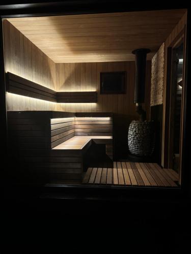 a sauna with a wooden deck in a dark room at Vasara in Rušenīca