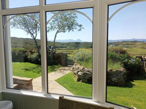 a window view of a garden from a house at 2 Guests - Garden & Patio - Sea Views in Strathcarron