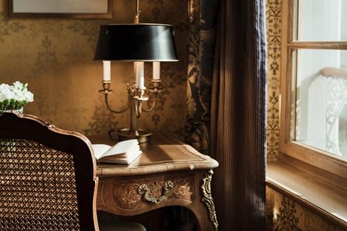 a lamp on a table next to a chair at Grand Hotel LES TROIS ROIS in Basel