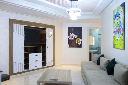 a living room with a couch and a tv at Larache haut standing in Larache