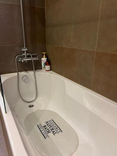 a bathroom with a bath tub with a sign on it at Modern Big Room with Balcony in New Apartment in Montijo