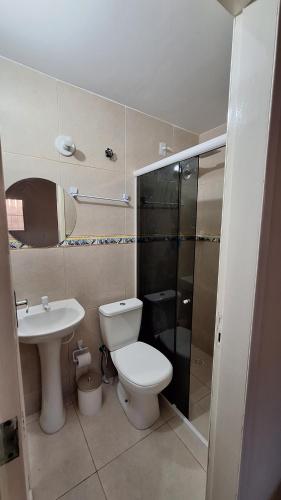a bathroom with a toilet and a sink at Casa temporada Martins,RN in Martins