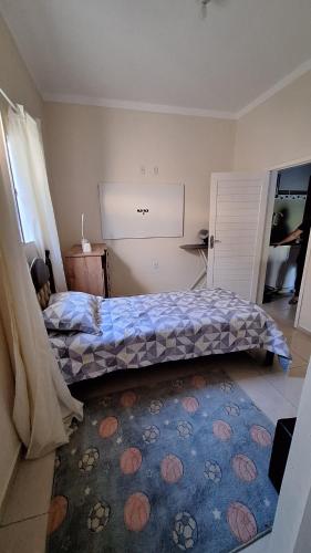 a bedroom with a bed and a rug on the floor at Casa temporada Martins,RN in Martins