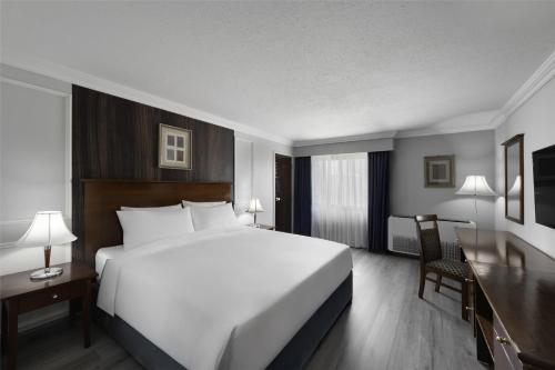 a hotel room with a large white bed and a desk at Radisson Blu Hotel, Yanbu in Yanbu