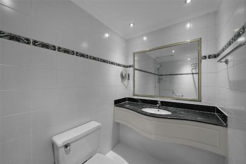 a white bathroom with a sink and a mirror at Radisson Blu Hotel, Yanbu in Yanbu