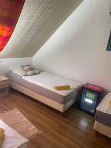 a small bedroom with a bed and a tv at Turul Panzió&Pizzéria in Szólád
