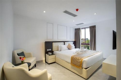 a hotel room with a bed and a chair at Royal Mark Hotel in Sylhet