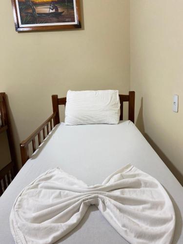 a bed with a white blanket on it at Hostel Manaus in Manaus
