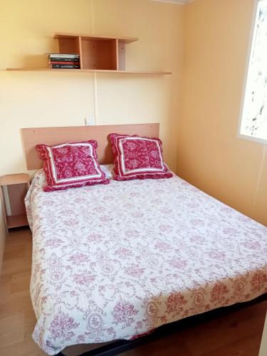 a bedroom with a bed with two red pillows at Ferme de ussau in Betchat