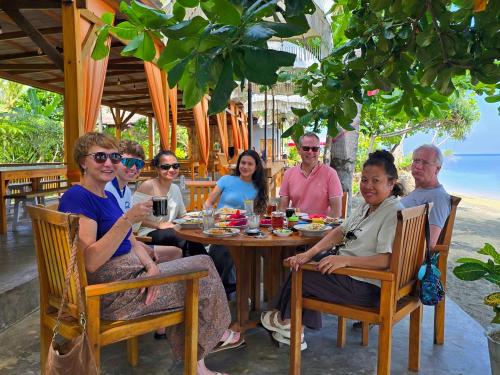 a group of people sitting around a table at a restaurant at Sunari Beach Resort Selayar - Real in Pareangang