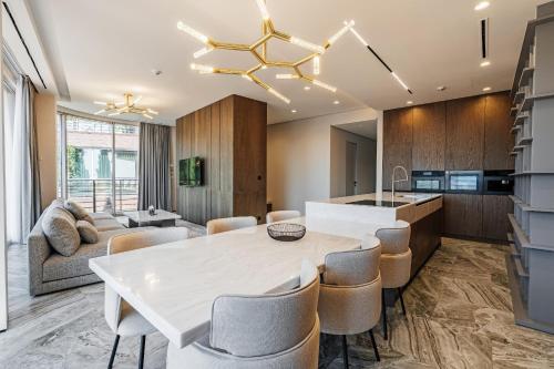 una cucina e un soggiorno con tavolo e sedie bianchi di Dukley Villa sea view a Budua