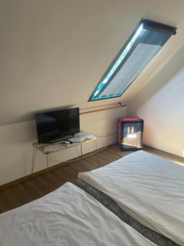 a bedroom with a bed and a tv and a window at Turul Panzió&Pizzéria in Szólád