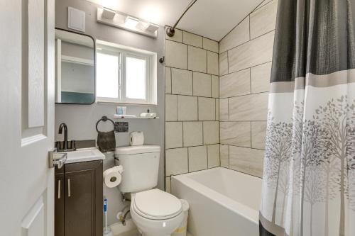 a bathroom with a toilet and a tub and a shower at 6 Mi to Riviera Beach WPB Retreat with Pool Access! in West Palm Beach