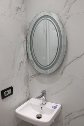 a bathroom with a white sink and a mirror at Joni`s Guesthouse in Shkodër