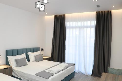 a bedroom with a bed and a large window at Joni`s Guesthouse in Shkodër